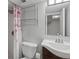 Bright bathroom with a toilet, a sink with dark wooden vanity, and a shower with glass shelving at 18093 E Milan Pl, Aurora, CO 80013
