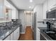 Modern kitchen featuring stainless steel appliances, granite countertops, and white cabinets at 18093 E Milan Pl, Aurora, CO 80013
