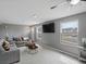 Bright living room with two windows, gray couches, and a ceiling fan showcasing ample natural light at 18093 E Milan Pl, Aurora, CO 80013