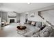 Bright living room featuring a white brick fireplace, ceiling fan, and gray couches on neutral carpet at 18093 E Milan Pl, Aurora, CO 80013