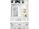 Stylish bathroom featuring a white vanity with black hardware, modern lighting and a large mirror at 4110 Hale Pkwy # 3K, Denver, CO 80220