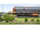 A restaurant with an outdoor dining area, yellow umbrellas, and lush green landscaping at 4110 Hale Pkwy # 3K, Denver, CO 80220