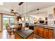 Modern kitchen with granite island, pendant lighting, wooden cabinets, and view of the adjacent living space at 1820 Sapling Ct, Castle Rock, CO 80109