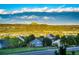 Scenic neighborhood view featuring cozy homes nestled among mature trees, set against a dramatic mountain backdrop at 1820 Sapling Ct, Castle Rock, CO 80109