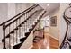 Stylish staircase with dark wood railing and carpeted steps at 10697 W Roxbury Ave, Littleton, CO 80127