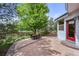 Outdoor patio with table and chairs surrounded by a manicured lawn and mature trees at 1190 W 11Th Ct, Broomfield, CO 80020