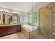 Bright bathroom featuring double sinks, tub with large window, and glass shower at 1190 W 11Th Ct, Broomfield, CO 80020