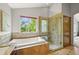 Bright bathroom featuring double sinks, tub, and glass shower with natural light at 1190 W 11Th Ct, Broomfield, CO 80020