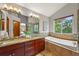 Bright bathroom featuring double sinks, tub, and large windows with natural light at 1190 W 11Th Ct, Broomfield, CO 80020