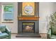 Living room with a dark gray painted brick fireplace, decorative wood mantel and a large round mirror above at 1190 W 11Th Ct, Broomfield, CO 80020