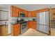 Well-equipped kitchen featuring wood cabinets, stainless steel appliances, and tile flooring at 1190 W 11Th Ct, Broomfield, CO 80020