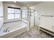 Bright bathroom featuring a large tub and glass-enclosed shower at 8951 E 59Th Pl, Denver, CO 80238