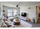 Bright living room featuring a large sectional sofa, round coffee table, and contemporary decor at 8951 E 59Th Pl, Denver, CO 80238