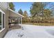 Covered patio, fenced backyard with snow and mature trees at 7261 E Hinsdale Ave, Centennial, CO 80112