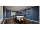 Dining room featuring a dark wood floor, blue accent wall, and a decorative mirror at 7261 E Hinsdale Ave, Centennial, CO 80112