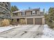 Two-story house with solar panels, attached two-car garage, and snow-covered driveway at 7261 E Hinsdale Ave, Centennial, CO 80112