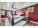 Main bedroom with a wooden bed frame, ceiling fan, and red walls at 7261 E Hinsdale Ave, Centennial, CO 80112