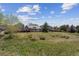 Aerial view of a home on a grassy lot with surrounding trees and a covered deck at 3787 Bucknell Dr, Highlands Ranch, CO 80129