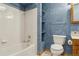 Cozy full bathroom with blue textured walls, white tile, and wood vanity at 3787 Bucknell Dr, Highlands Ranch, CO 80129