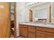 Bright bathroom with dual sinks, wood cabinets, and a view into the primary bedroom at 3787 Bucknell Dr, Highlands Ranch, CO 80129