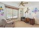 Bedroom with a window, chair, side desk, and butterfly artwork around the room at 3787 Bucknell Dr, Highlands Ranch, CO 80129