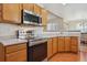 Bright kitchen featuring stainless steel appliances, wood cabinetry, and a pass-through window at 3787 Bucknell Dr, Highlands Ranch, CO 80129