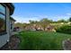 Expansive backyard with lush green grass, terraced landscaping, and outdoor seating area at 5810 Amber Ridge Dr, Castle Pines, CO 80108