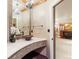 Powder room boasting unique tile accents, granite countertops, and designer fixtures at 5810 Amber Ridge Dr, Castle Pines, CO 80108