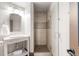 Bathroom with a decorative glass shower, single sink vanity, and stylish mirror with modern lighting at 5810 Amber Ridge Dr, Castle Pines, CO 80108