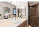 Bathroom with double sinks, large mirror, and window showcasing the home's interior at 5810 Amber Ridge Dr, Castle Pines, CO 80108
