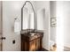 Elegant powder room with an ornately carved wood vanity, vessel sink and decorative mirror at 5810 Amber Ridge Dr, Castle Pines, CO 80108