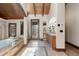 Bright and airy bathroom with a soaking tub, lots of mirrors, and a wooden ceiling at 5810 Amber Ridge Dr, Castle Pines, CO 80108