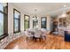 Bright breakfast nook with large windows, stone accent wall, and wood flooring at 5810 Amber Ridge Dr, Castle Pines, CO 80108