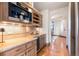 Butler's pantry with built in coffee maker, wine storage, and under cabinet lighting at 5810 Amber Ridge Dr, Castle Pines, CO 80108