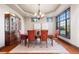 Elegant dining room featuring a tray ceiling, chandelier, large window, and formal wooden furniture at 5810 Amber Ridge Dr, Castle Pines, CO 80108