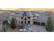 A lavish two-story home with elegant stonework, manicured landscaping, and a circular driveway at 5810 Amber Ridge Dr, Castle Pines, CO 80108