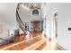 Grand foyer with curved staircase, stone accent wall and hardwood floors at 5810 Amber Ridge Dr, Castle Pines, CO 80108