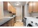 Functional laundry room with sink, storage cabinets and modern appliances at 5810 Amber Ridge Dr, Castle Pines, CO 80108