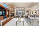 Bright living room showcasing a stone fireplace, large windows, and comfortable seating at 5810 Amber Ridge Dr, Castle Pines, CO 80108