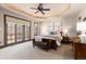 Beautiful primary bedroom featuring tray ceilings, a ceiling fan, and access to the private patio at 5810 Amber Ridge Dr, Castle Pines, CO 80108