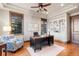 Bright office with hardwood floors, a ceiling fan, custom bookshelves, and an executive desk setup at 5810 Amber Ridge Dr, Castle Pines, CO 80108
