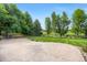 Beautifully landscaped backyard with a stone patio and lush lawn, surrounded by mature trees and greenery at 8937 Little Raven Trl, Niwot, CO 80503