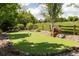 Backyard putting green is surrounded by lush landscaping and mature trees at 8937 Little Raven Trl, Niwot, CO 80503