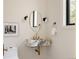 Powder room featuring a marble sink, gold fixtures, and decorative mirror at 8937 Little Raven Trl, Niwot, CO 80503