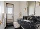 Modern bathroom featuring black marble countertops, herringbone floors, and glass shower enclosure at 8937 Little Raven Trl, Niwot, CO 80503