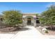 Inviting stone and stucco front entrance with arched doorway and lush landscaping at 8937 Little Raven Trl, Niwot, CO 80503