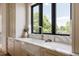 Kitchen sink with black frame window, marble countertops and backsplash, and gooseneck faucet at 8937 Little Raven Trl, Niwot, CO 80503