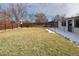 Spacious backyard with grass, a wooden privacy fence, and partial snow coverage at 555 W Peakview Ave, Littleton, CO 80120