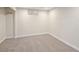 A neutral-toned basement room with carpet, white trim, and natural light from a small window at 555 W Peakview Ave, Littleton, CO 80120