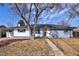 Inviting single-story home with mature tree, lush landscaping, and neutral color scheme creating curb appeal at 555 W Peakview Ave, Littleton, CO 80120